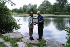 Kiersten Denning (left) is awarded with the A.W. Campbell Memorial Scholarship by St. Clair Region Conservation Authority Chair, Mike Stark (right) in front of the reservoir in Strathroy..