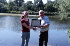 Tesni Greig Clark (left) is awarded with the A.W. Campbell Memorial Scholarship by St. Clair Region Conservation Authority Chair, Mike Stark (right) in front of the reservoir in Strathroy..