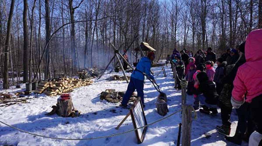 SCRCA staff demonstrate historical maple syrup production methods to a crowd at the A.W. Campbell Conservation Area
